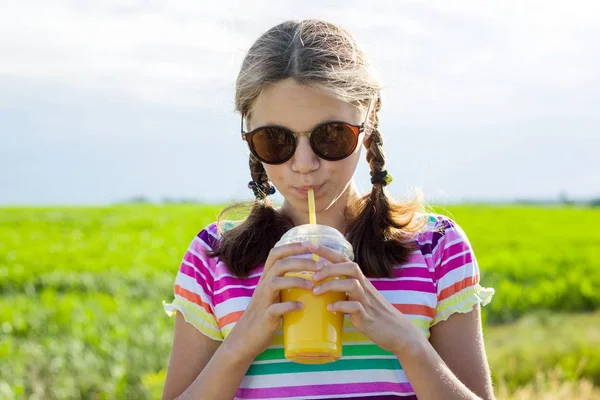 Menina adolescente feliz beber suco de laranja no dia quente de verão . — Fotografia de Stock