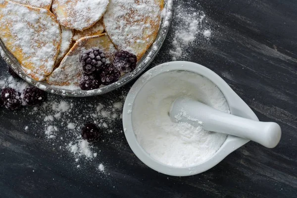 Homemade pancakes with blackberries, powdered sugar. Dark background. — Stock Photo, Image