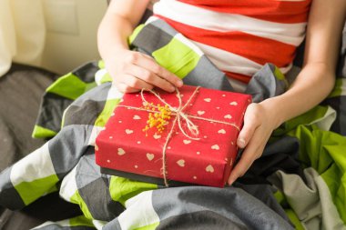 Hediye elinde. Kırmızı Kalpler, sarı Mimoza çiçekler bir şube ile dekore edilmiş kağıt işçiliği Paketli.