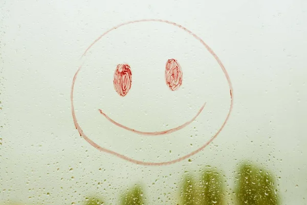 Positive funny smiley on a rainy window — Stock Photo, Image