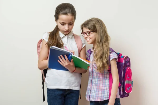 Τα παιδιά το σχολείο τις φίλες. Το μεγαλύτερο κορίτσι δείχνει νεότερος σημειωματάριο. — Φωτογραφία Αρχείου