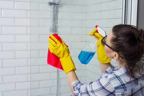 Lavoro domestico e stile di vita domestico. Donna che pulisce vasca da bagno con un panno — Foto Stock