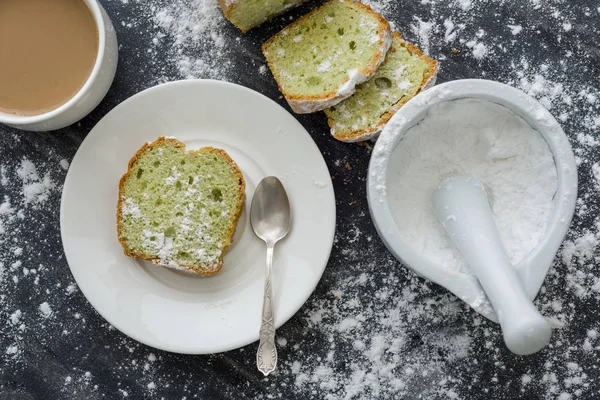 Minzkuchen mit Puderzucker auf dunkler Oberfläche mit einer Tasse Kaffee bestreut — Stockfoto