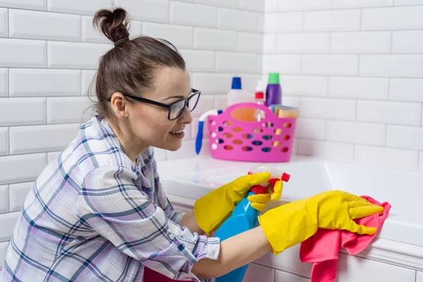 Huishoudelijk werk en binnenlandse levensstijl. Vrouw in badkuip met een doek schoonmaken — Stockfoto