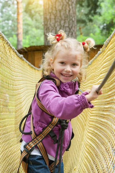 A menina é de 4 anos de idade em aventura escalada parque de arame alto, estilo de vida ativo de crianças — Fotografia de Stock