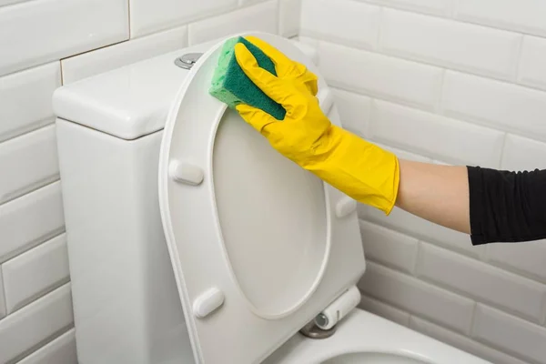 La mujer está limpiando en el baño. Lavar el inodoro . —  Fotos de Stock