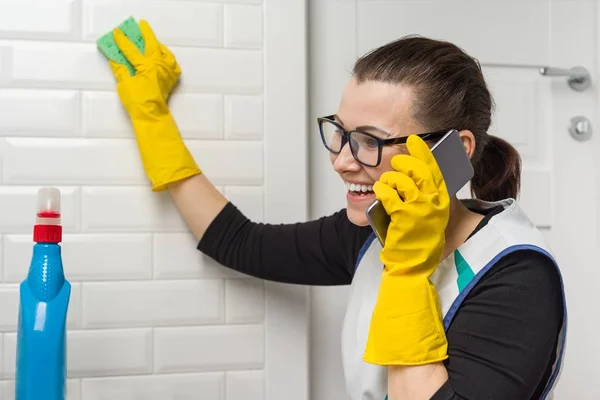 Hausfrau putzt im Badezimmer und telefoniert — Stockfoto