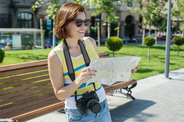 Szczęśliwa kobieta podróży turystycznych, trzymając aparat i mapy. — Zdjęcie stockowe