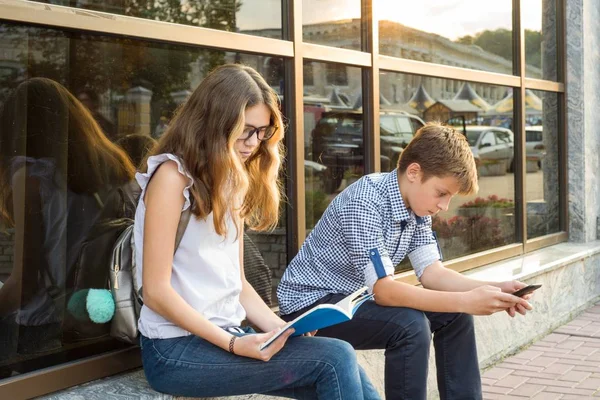 Kinder Teenager, lesen Bücher und nutzen Smartphone. — Stockfoto