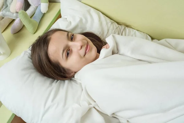Niña con cabello castaño largo durmiendo en una almohada en la cama — Foto de Stock