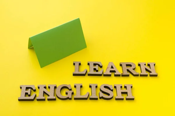 Aprender Inglês, palavras em letras de madeira com fundo amarelo — Fotografia de Stock