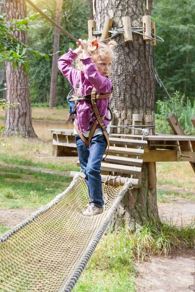 Menina criança em aventura escalada alto fio parque, estilo de vida ativo de crianças — Fotografia de Stock