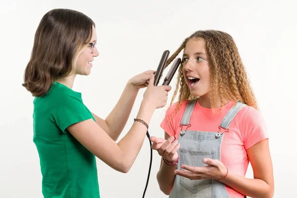 Potret dua pacar remaja melakukan gaya rambut di rumah. Latar belakang putih — Stok Foto