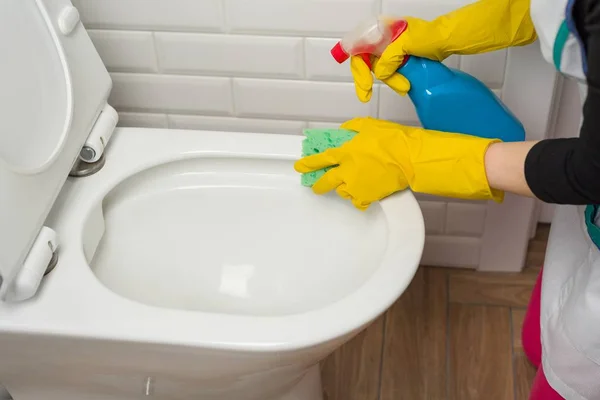 La donna sta pulendo in bagno. Lavare la toilette . — Foto Stock