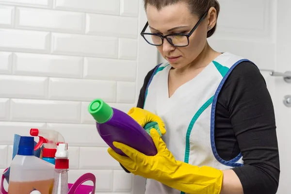 Hemmafru kvinna gör rengöring med intresse läst instruktionerna på tvättmedel — Stockfoto