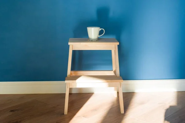 Uma xícara fica em uma cadeira de madeira . — Fotografia de Stock