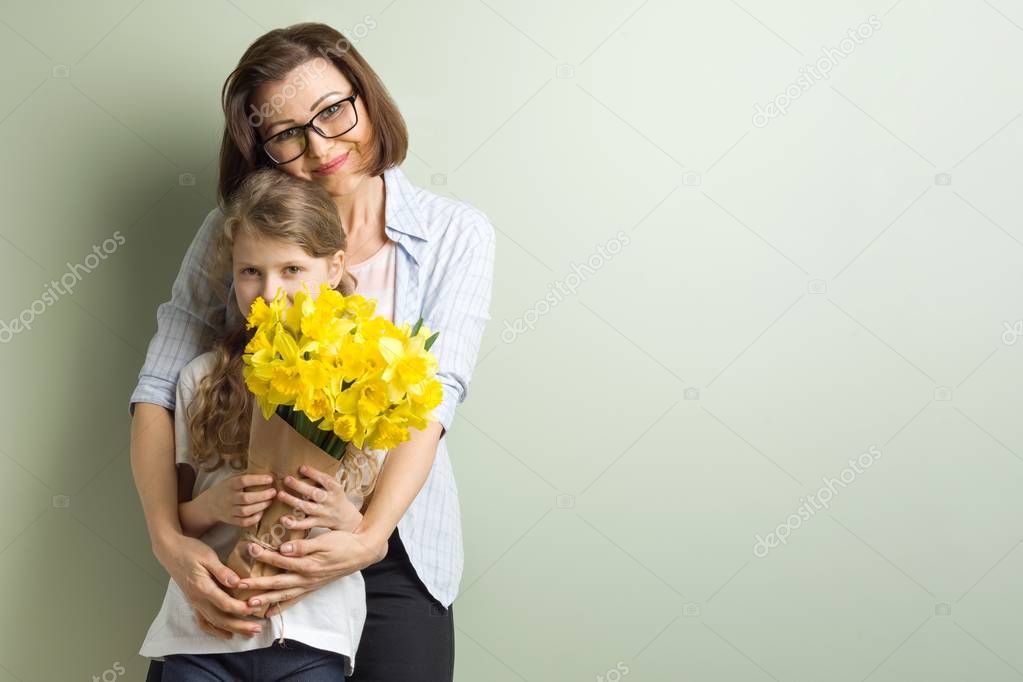 Child congratulates mother and gives her bouquet