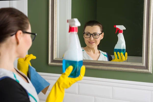 Vrouw reinigt spiegel thuis — Stockfoto