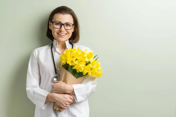 Mujer sonriente médico con ramo —  Fotos de Stock