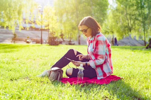 Volwassen middelbare leeftijd vrouw zit in stadspark — Stockfoto