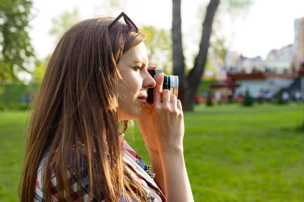 Mujer tomando fotos en la cámara al atardecer —  Fotos de Stock