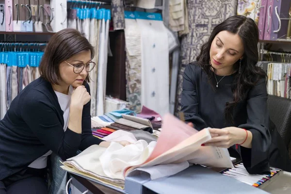 Vendedor - designer têxtil aconselha mulher comprador — Fotografia de Stock