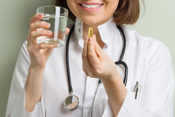 Female doctor takes vitamin capsule. — Stock Photo, Image