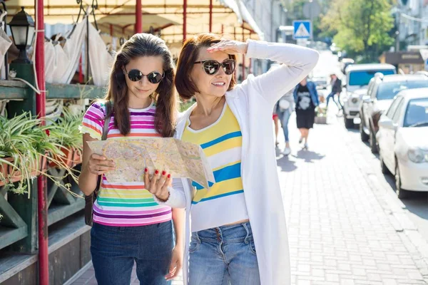 Мать и дочь-подросток на городской улице смотрят на карту. Путешествующие семьи . — стоковое фото