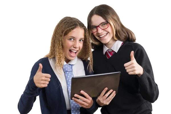 Szczęśliwy szkoła przyjaciele zbliżenie portret. Nastoletnie dziewczyny w szkole jednolitego z tabletu i pokazuje kciuk w, obraz jest na białym tle — Zdjęcie stockowe