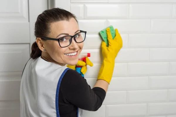 Porträt einer Reinigungskraft, die Gummihandschuhe trägt, Schwamm und Waschmittel in der Hand hält, Kopierraum — Stockfoto