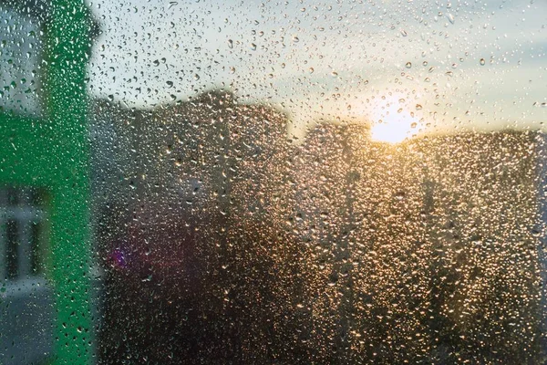 도시의 석양 배경 창에 큰 빗방울 — 스톡 사진