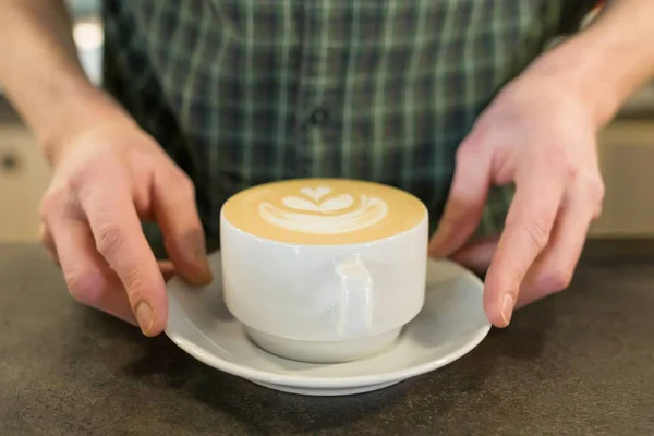 男性バリスタの手によるコーヒーアートのカップ — ストック写真
