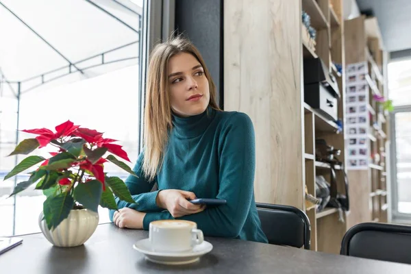 Retrato de invierno de la mujer sentada en la cafetería con taza de café — Foto de Stock