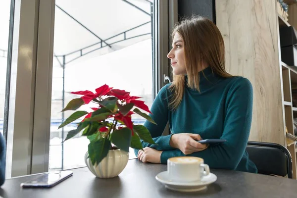 Retrato de invierno de la mujer sentada en la cafetería con taza de café — Foto de Stock