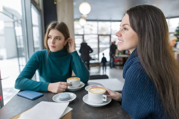 Two young beautiful women in cafe with cup of coffee talking in the break — Stock Photo, Image