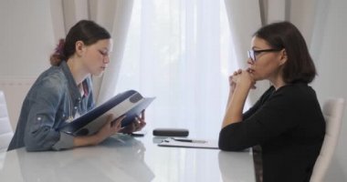 Kadın profesyonel psikoterapist, psikolog ofiste genç bir kızla konuşuyor.