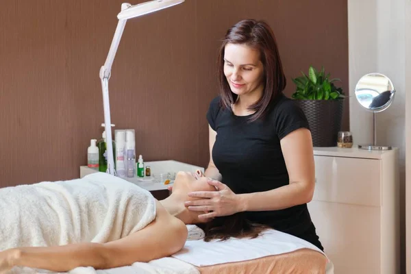 Retrato de mulher esteticista trabalhando com paciente do sexo feminino na clínica de beleza . — Fotografia de Stock