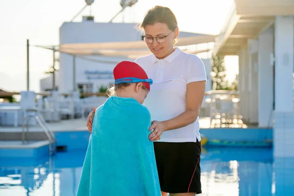 Мать и дочь ребенка в шляпе очки для плавания с полотенцем возле бассейна — стоковое фото