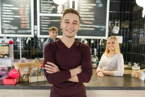 バーカウンター近くの喫茶店でポーズをとって笑顔になる3人の若いチーム — ストック写真