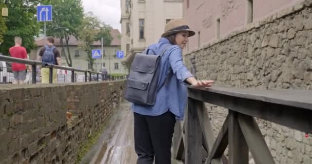 Donna adulta in cappello con zaino che cammina nella città vecchia, vista posteriore — Video Stock