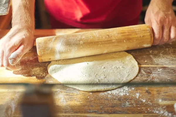 Nahaufnahme männlicher Bäckerhände mit Mehlkoch Teig mit Nudelholz ausrollen — Stockfoto