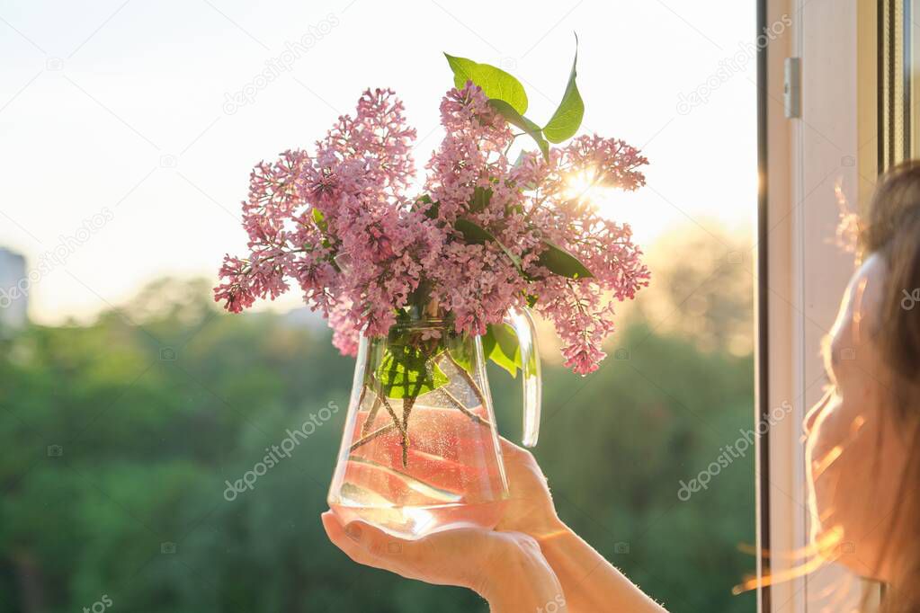 Bouquet of flowers lilac in jug in womans hand