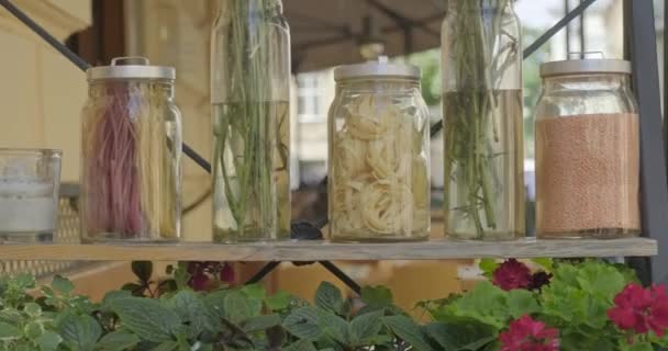 Frascos decorativos con pasta, espaguetis con botellas y flores — Vídeos de Stock