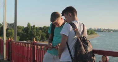 Akıllı telefon kullanarak iki arkadaş genç erkek, konuşma ve gülümseyen