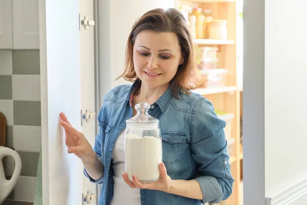 Mujer adulta en interior de la cocina con productos alimenticios — Foto de Stock