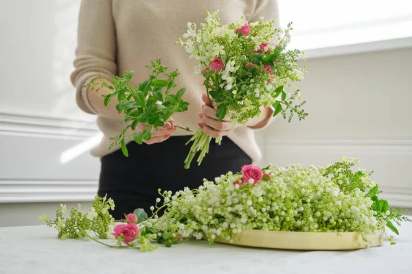 ピンクのバラの花の花束を作る女性の花屋の手、谷の新鮮なユリ. — ストック写真