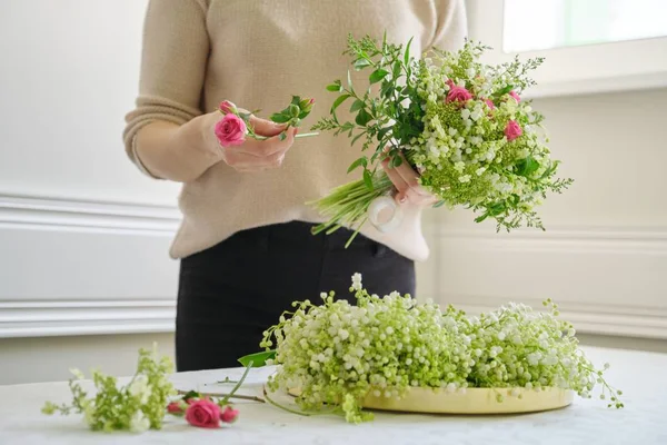 花束を作るテーブルの上に異なる花を持つ女性花屋 — ストック写真