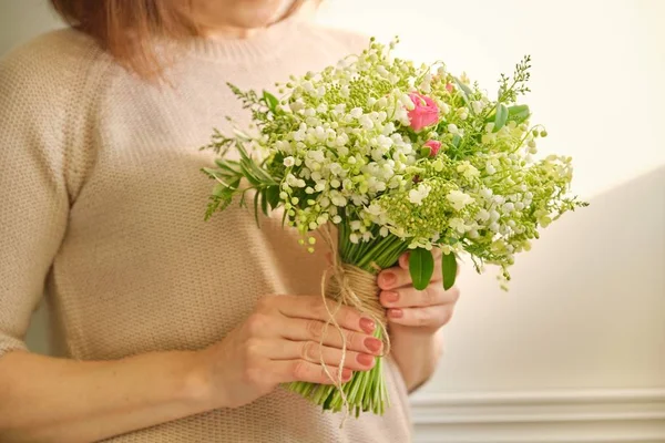 Belo buquê fresco de lírio das flores do vale, rosa rosa, ramos verdes na mão da mulher — Fotografia de Stock