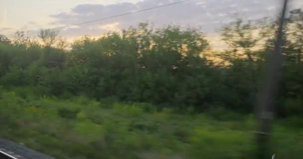 Viaggi in treno, paesaggi reali, paesaggi serali, tramonto nella stagione estiva . — Video Stock