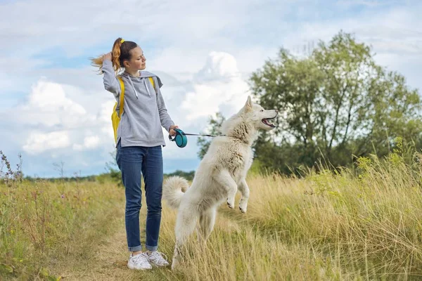 Vacker flicka med vit hund, tonåring promenader med husky husdjur — Stockfoto